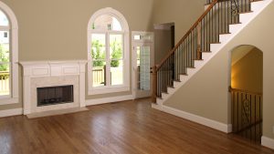 new wood flooring in an empty living room with fireplace and stairs