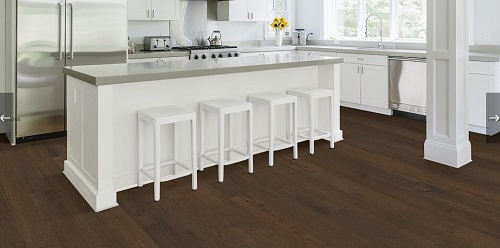hardwood flooring in a bright kitchen with island and stools